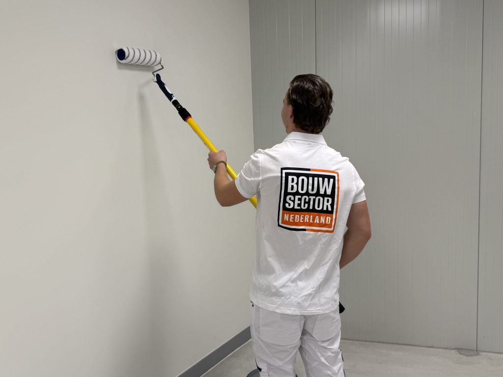 Schilder van Bouwsector Nederland aan het werk aan een binnenraam