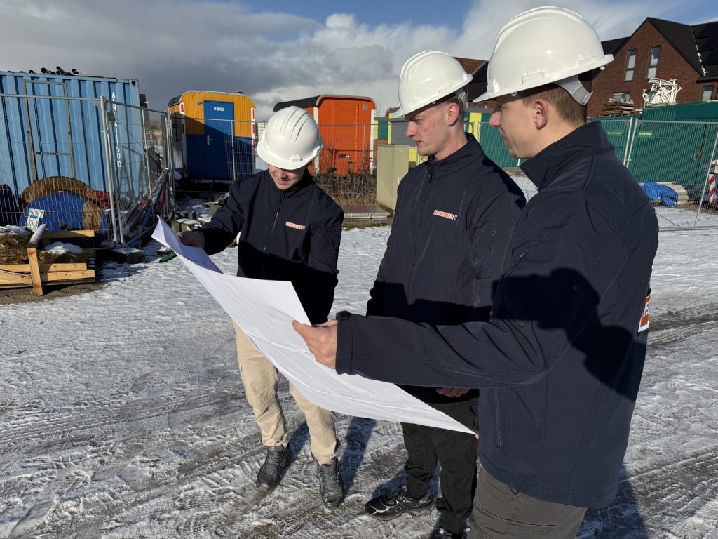 Drie medewerkers van Bouwsector Nederland bekijken een bouwtekening